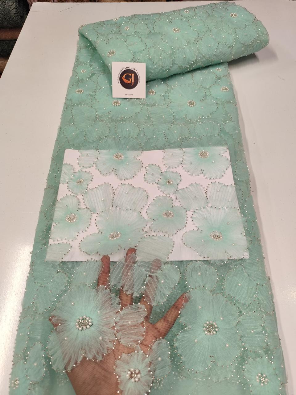 Tissu dentelle vert menthe avec motifs floraux et sequins argentés