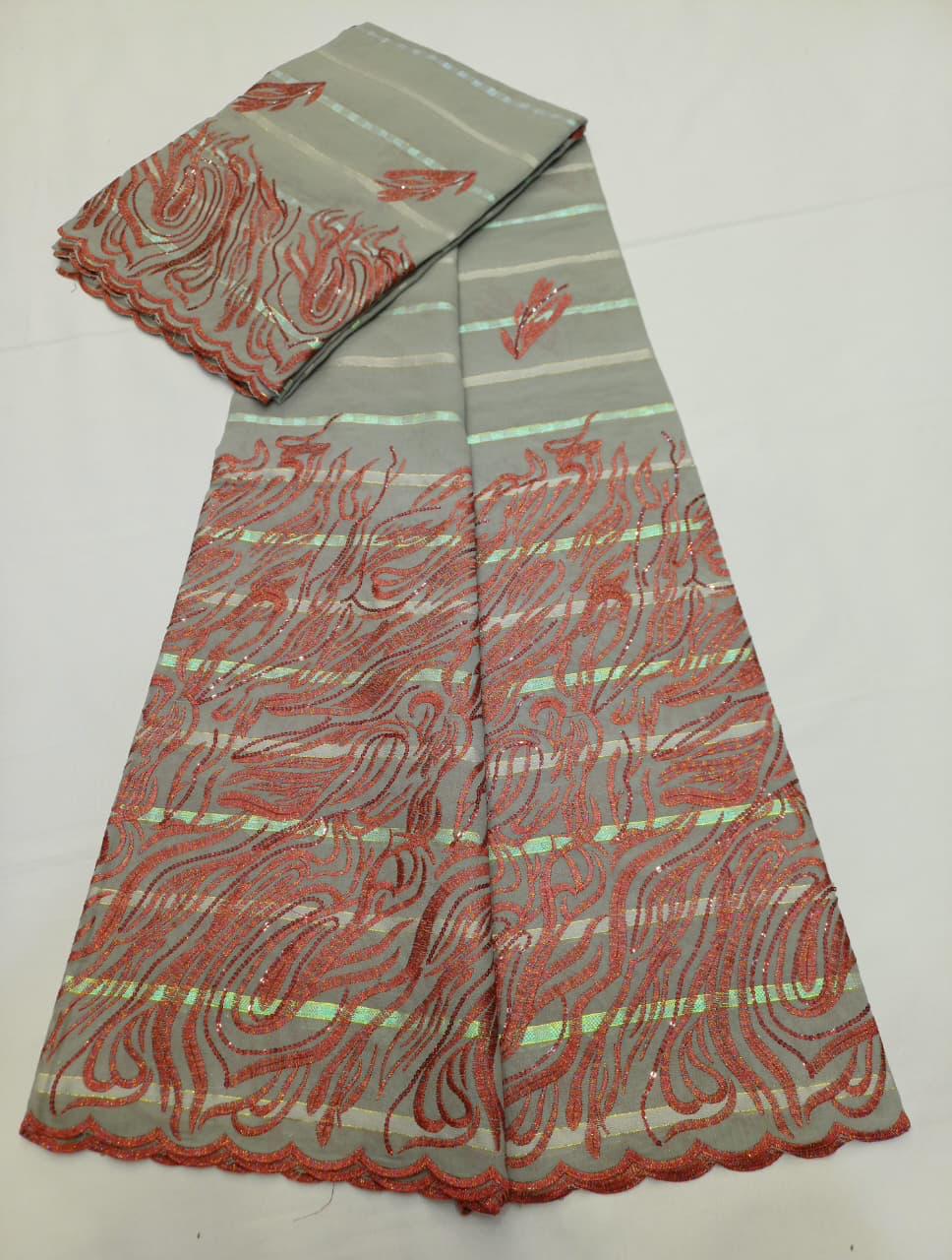 Tissu Salouva pêche avec motifs verts scintillants et bordure festonnée