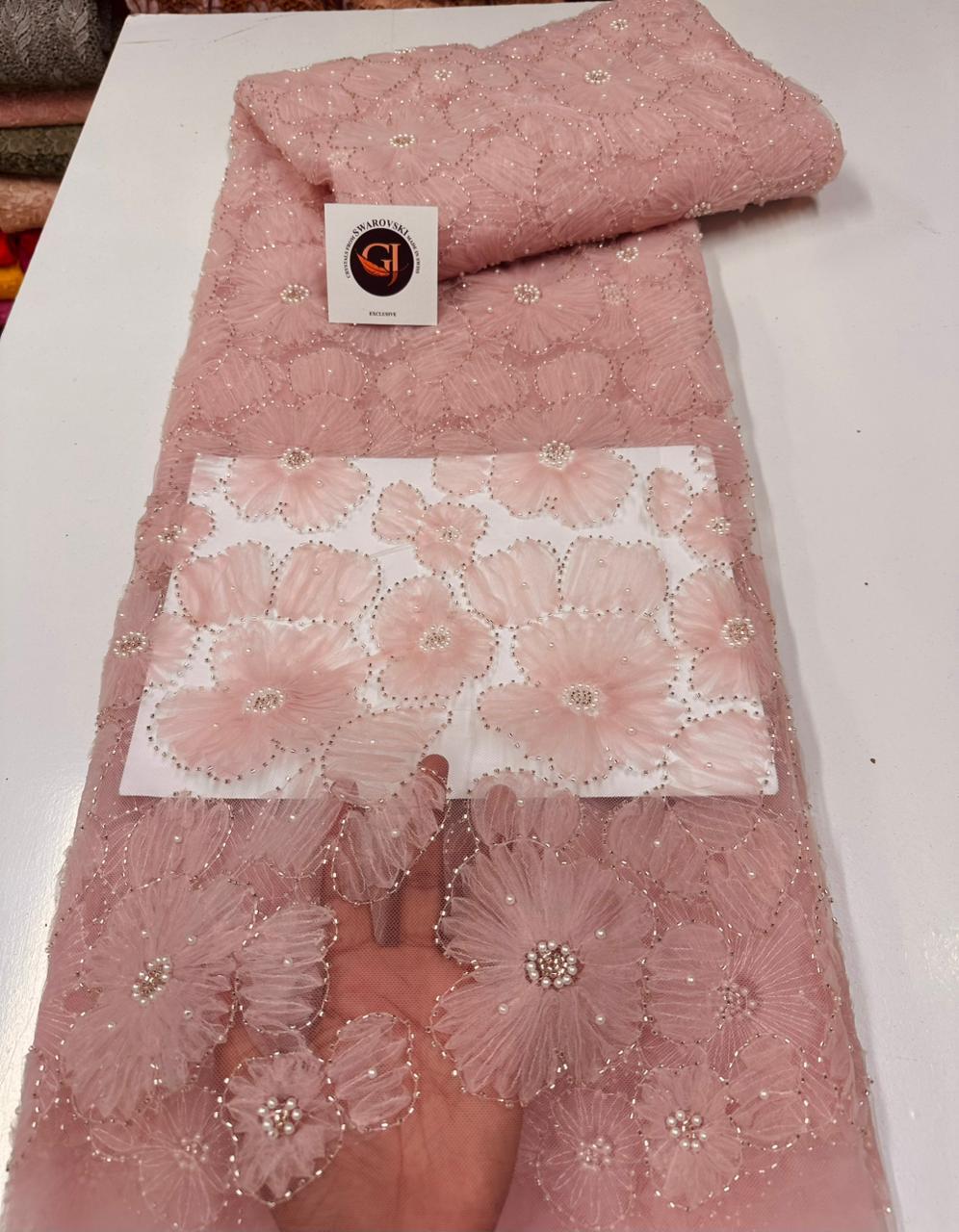 Tissu dentelle mauve avec motifs floraux et détails scintillants